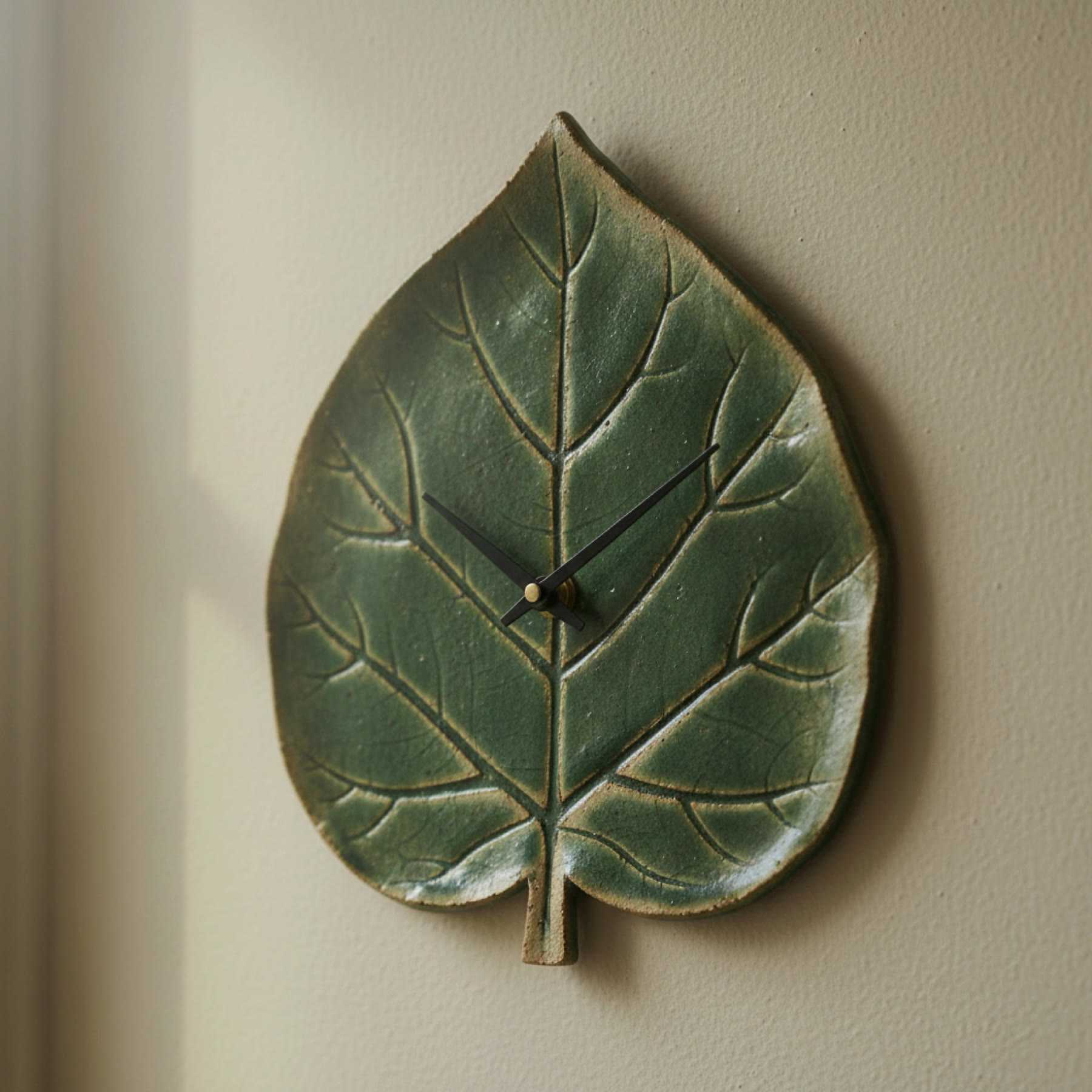 Illustration of a green leaf-shaped ceramic wall clock