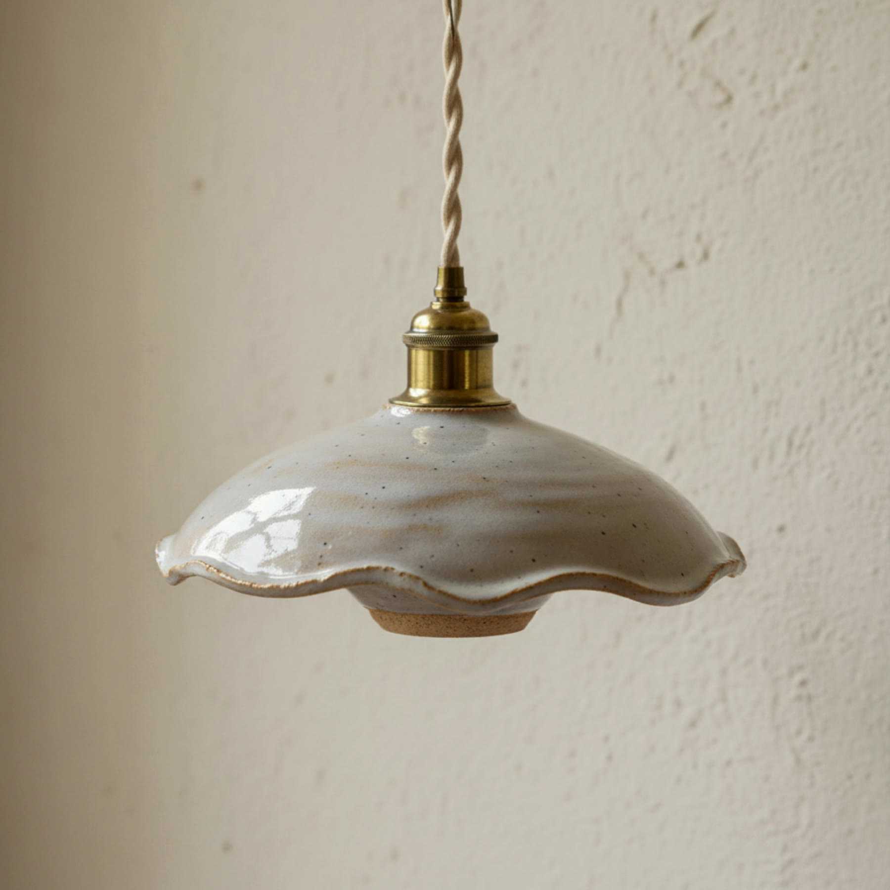 Illustration of a ruffled grey-white ceramic pendant lampshade with a brass fitting