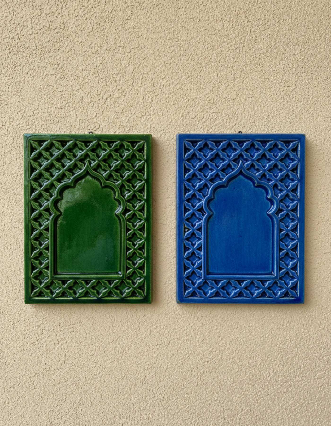 Illustration of two ceramic house plaques, green and blue, each a Mughal arch in a jaali lattice border