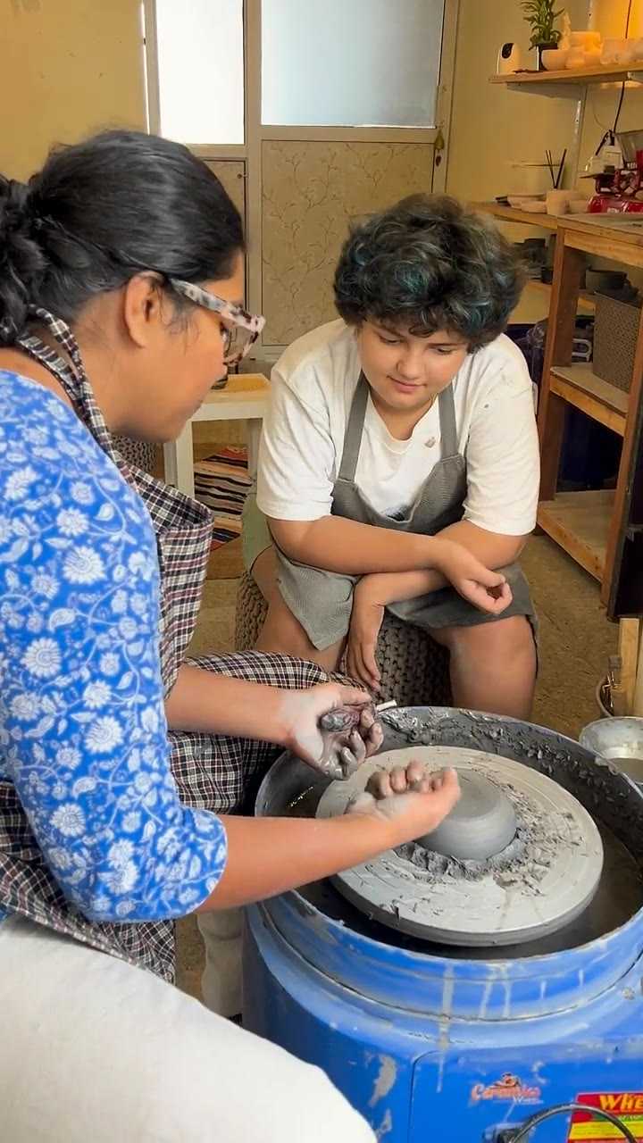 Madhumita guiding a young student's hands on the wheel