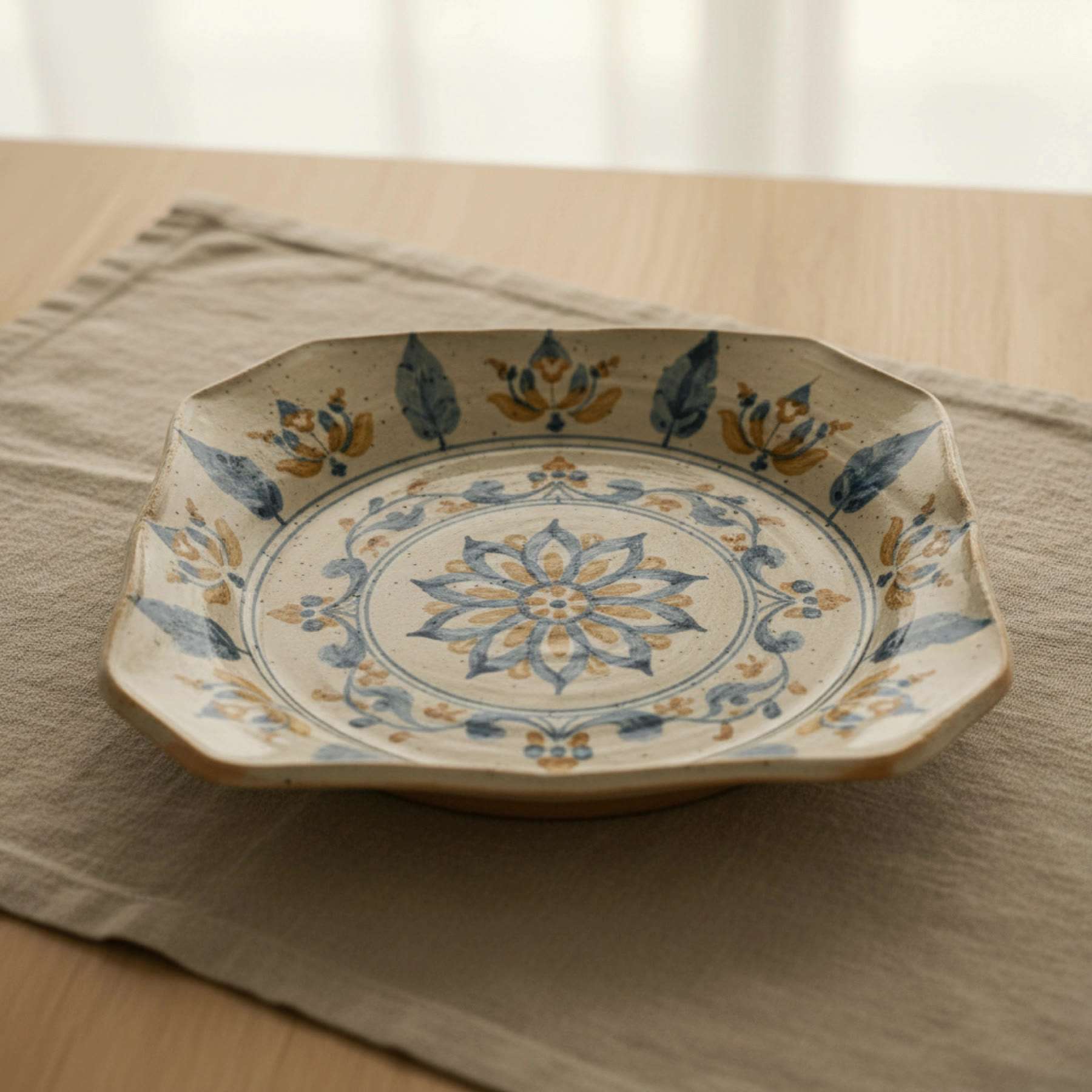 Illustration, from above, of a plate painted all over with a blue lotus medallion and floral border
