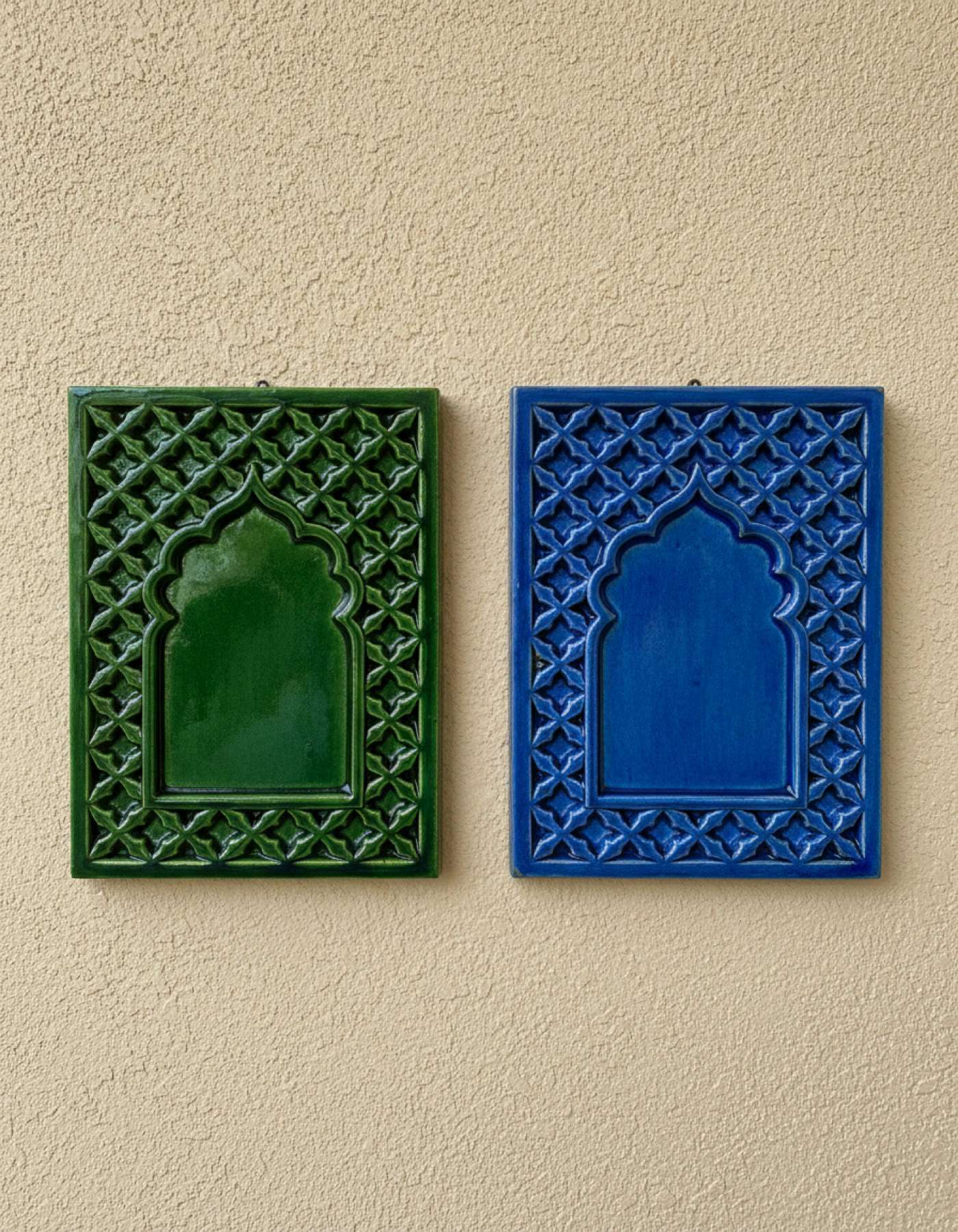 Illustration of two ceramic house plaques, green and blue, each a Mughal arch in a jaali lattice border