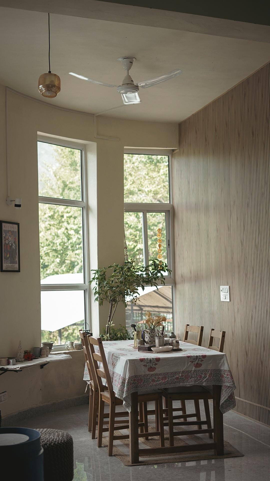 Sunlit studio with communal table and wooden slat wall