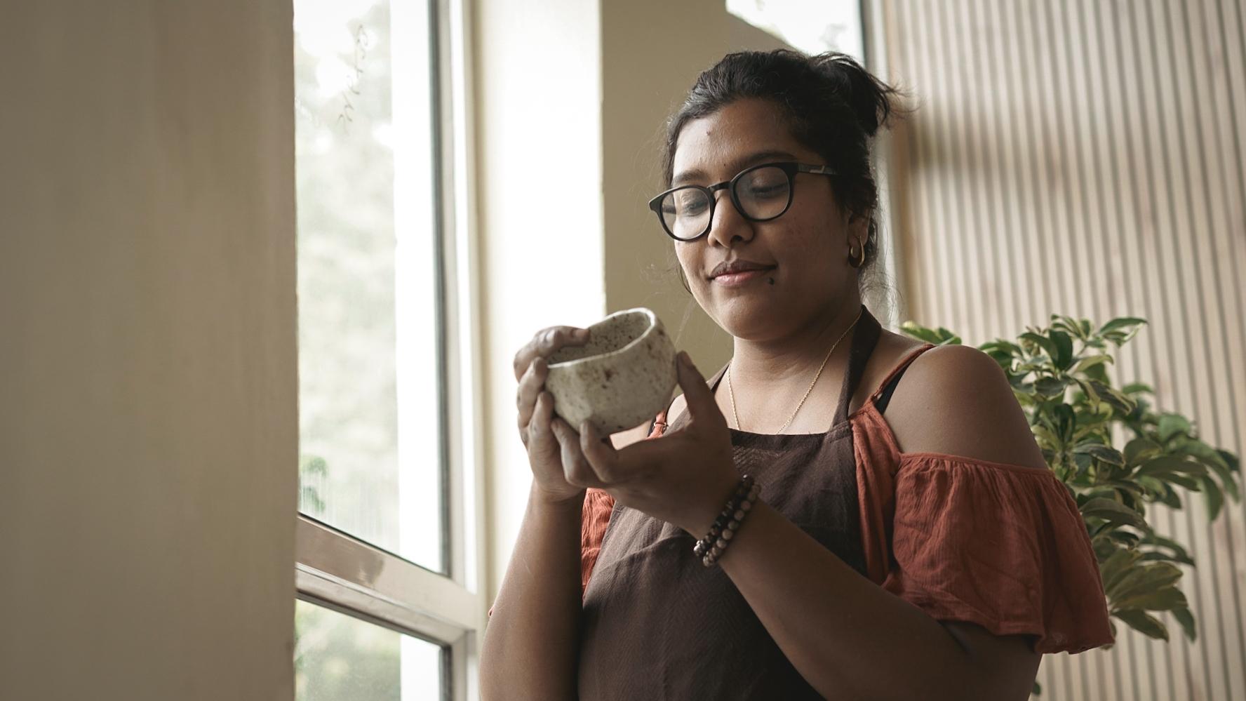 Madhumita Chatterjee admiring a hand-pinched speckled bowl