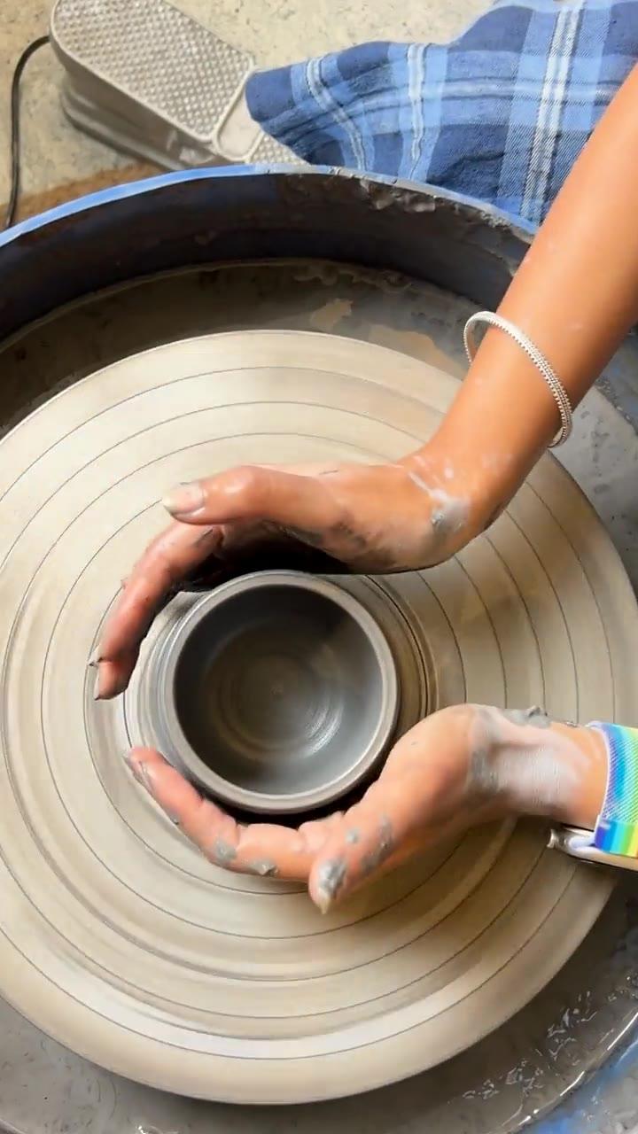 Hands centring clay on the wheel, seen from above