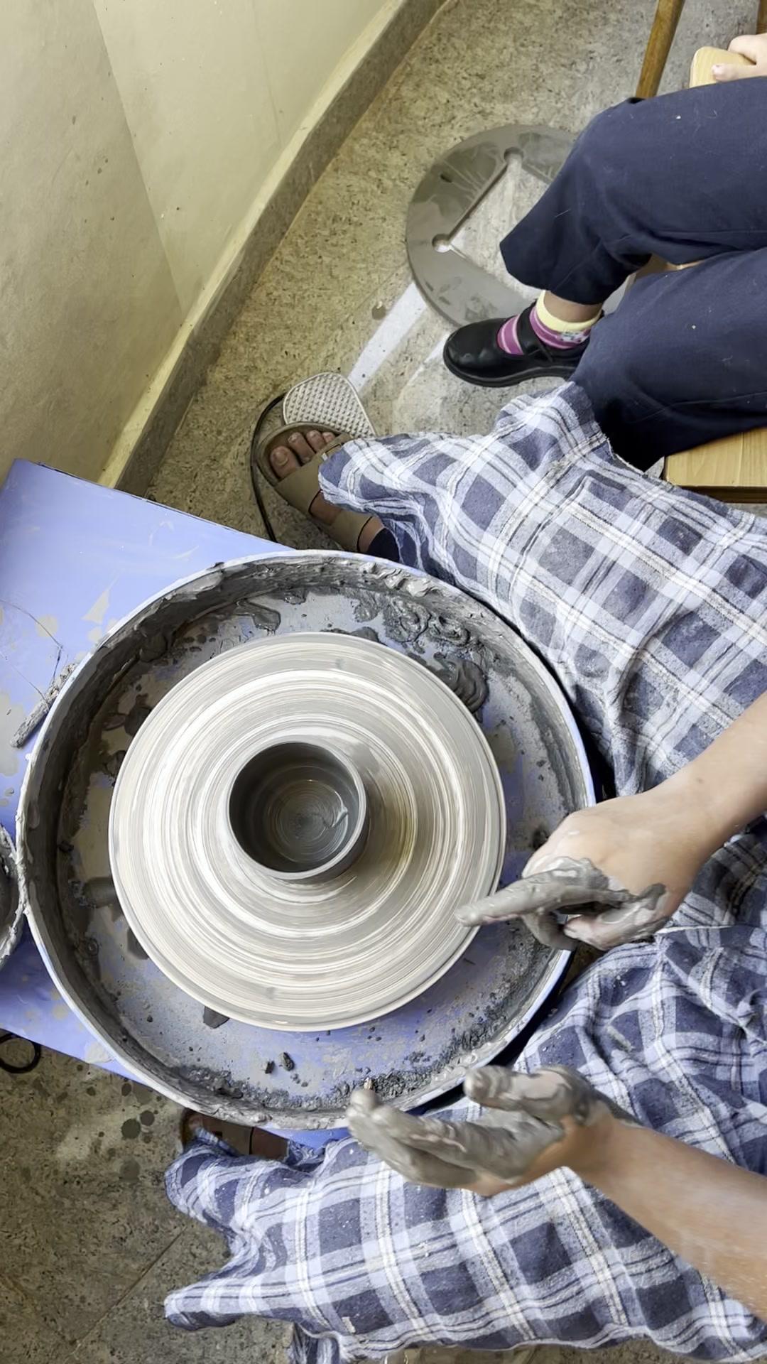 Pottery wheel spinning with clay being shaped in the studio