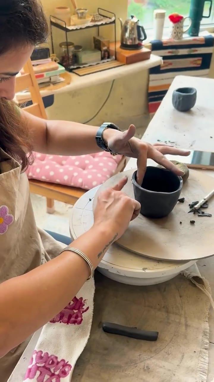 A leather-hard bowl held upside down on the wheel while a foot ring is trimmed