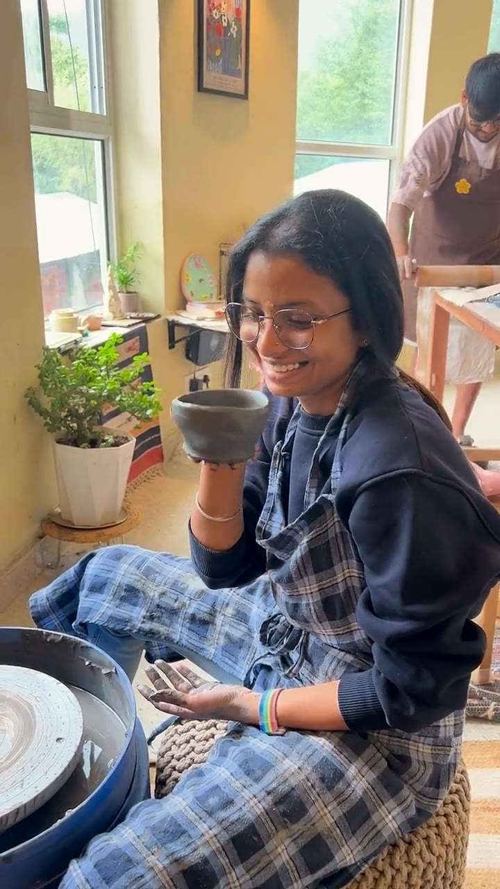 A guest drinking from the cup she made, then holding it up to look at it