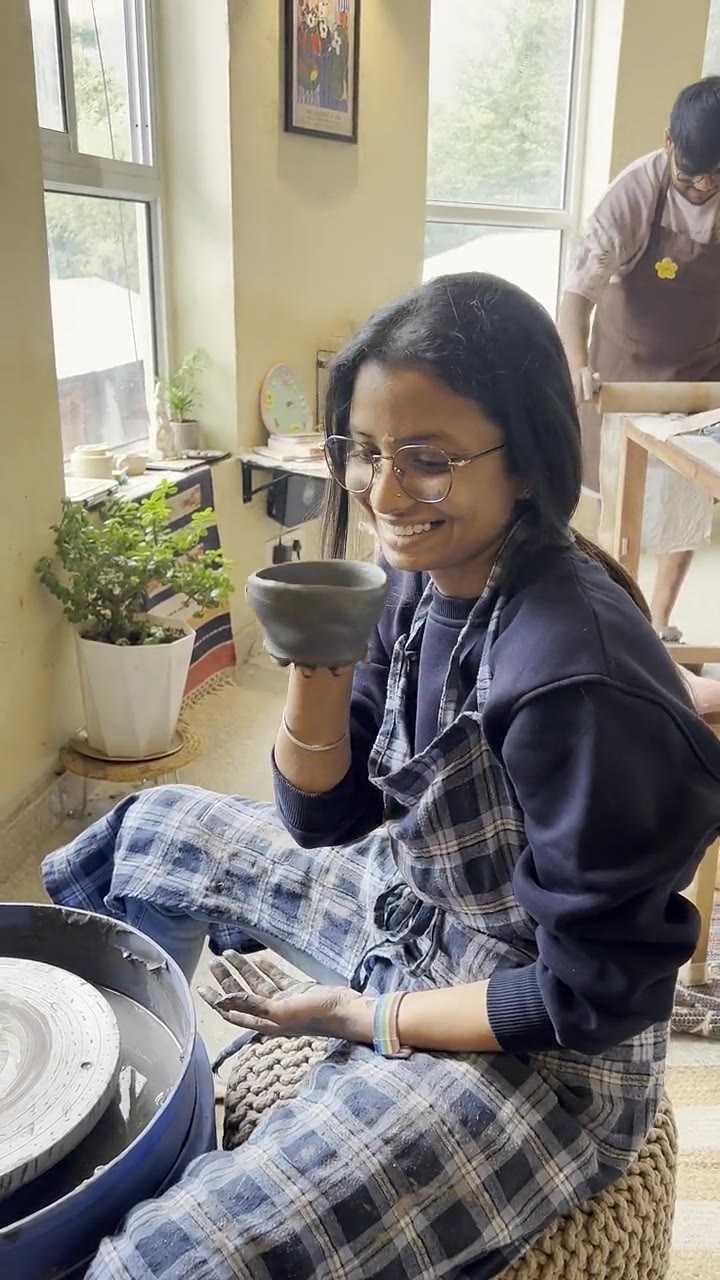 A guest drinking from a cup she made, then holding it up to look at it