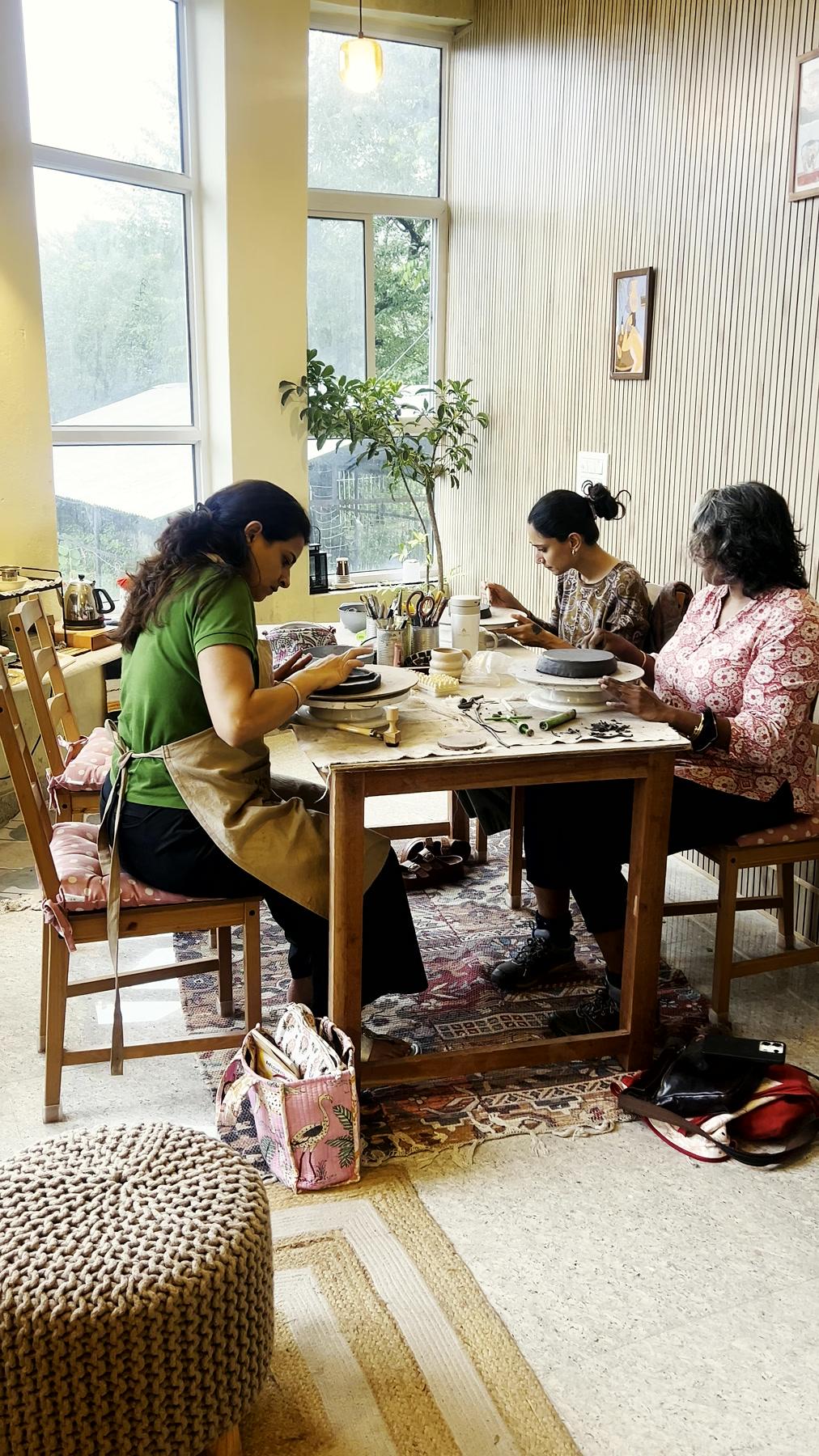 A session in progress, several people working clay at the long table