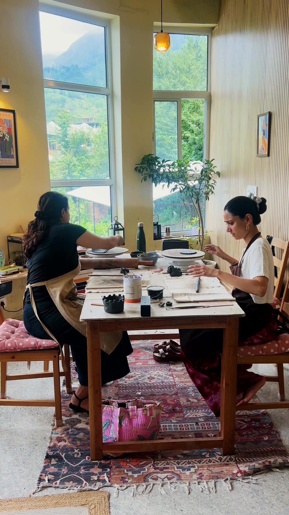 The studio's tall windows and work tables, the valley beyond the glass